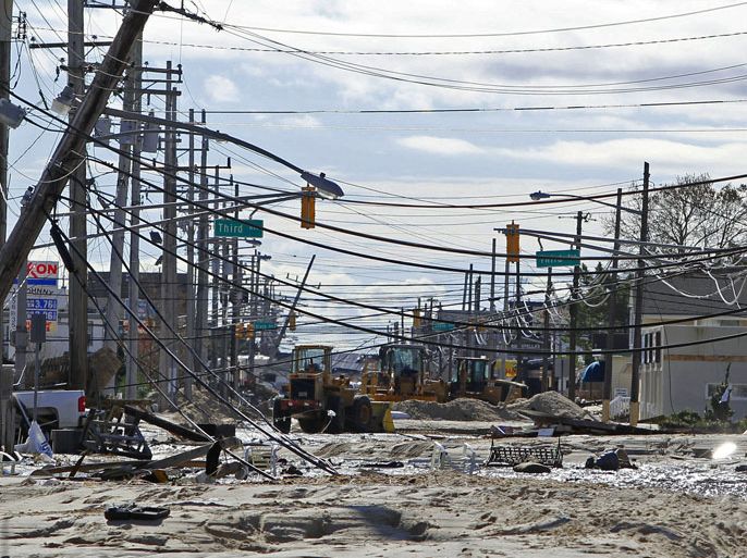 epa03454142 Route 35 North is covered in sand and debris as crews weave between power lines during clean up in Ortley Beach, New Jersey, USA, 31 October 2012, two days after Hurricane Sandy hit the area. Thousands of people were still stranded two days after the massive superstorm Sandy slammed the US East Coast, as the death toll rose to as high as 50. In Hoboken, New Jersey, across the Hudson River from Manhattan, some 20,000 people were isolated by filthy high water. National Guard units arrived with supplies and used troop transports in the rescue, according to media reports. EPA/SAED HINDASH / THE STRAR-LEDGER / POOL