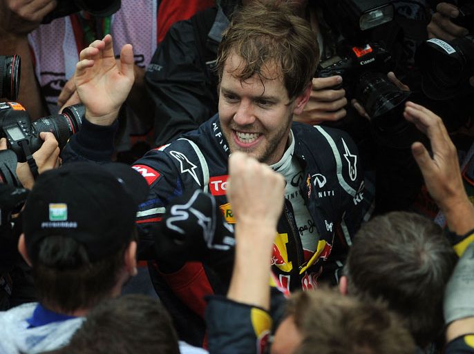 German Formula One driver Sebastian Vettel celebrates with the Red Bull team his F-1 World Championship after arriving 6th in the Brazil's F-1 GP on November 25, 2012, at the Interlagos racetrack in Sao Paulo, Brazil. AFP PHOTO/NELSON ALMEIDA
