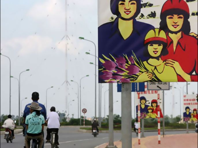 afp : posters are seen asking people to wear helmets, along a highway in the outskirts of hanoi, 31 august 2007. motorcyclists in vietnam will be forced to wear helmets late (الفرنسية)