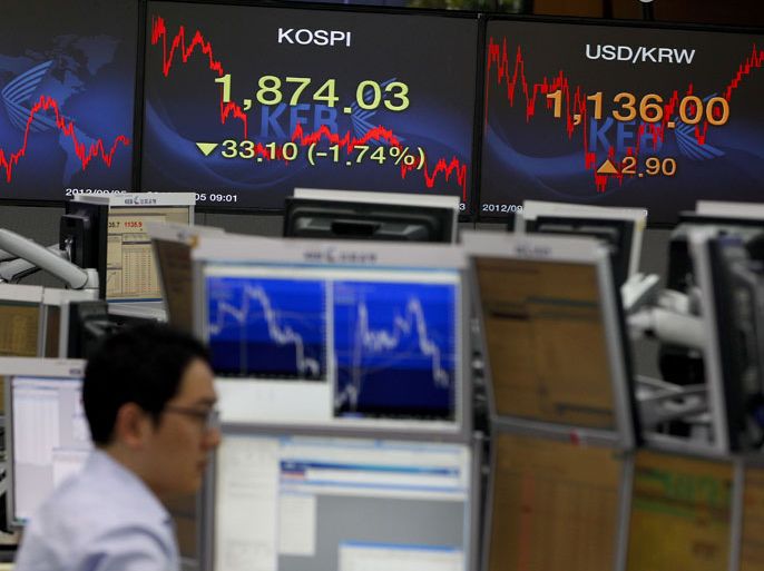 epa03383917 A South Korean Exchange Bank dealer works in front of monitors at the Exchange Bank in Seoul, South Korea. 05 September 2012. The benchmark Korea Composite Stock Price Index (KOSPI) retreated 33.10 points to