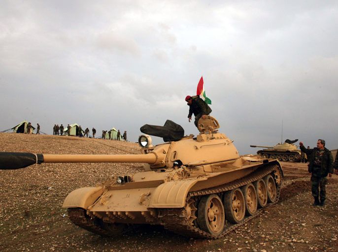 IRAQ : An Iraqi Kurdish peshmerga soldier stands on a tank, flying the Kurdish flag, stationed 20 kilometres north of Kirkuk on November 24, 2012. Iraq's parliament speaker Osama al-Nujaifi said that "significant progress" has been made on resolving an Arab-Kurd crisis, although a deployment of Kurdish forces in the country's north has raised the stakes. AFP PHOTO / SAFIN HAMED