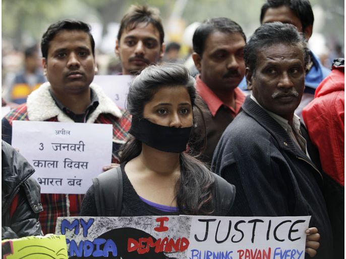 Indian protesters hold banners and wear black ribbons during a rally in New Delhi on December 30, 2012
