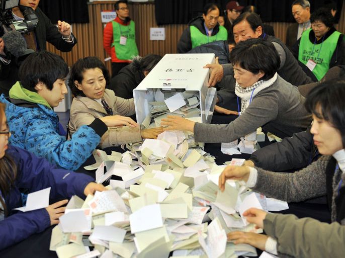 JYJ264 - SEOUL, -, REPUBLIC OF KOREA : South Korean election officials count ballots for the presidential election at a high school gymnasium in Seoul on December 19, 2012