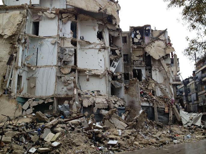 مبنى سكني في حي بستان الباشا سقط عليه برميل متفجرات (الجزيرة نت)