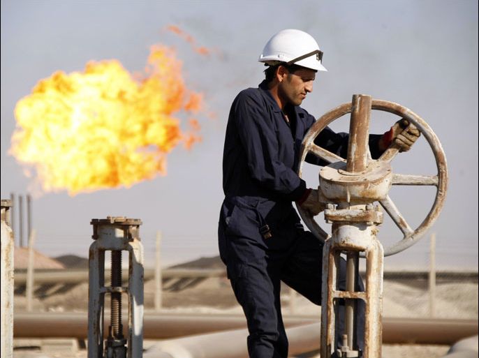 A worker adjusts the valve of an oil pipe at West Qurna oilfield in Iraq's southern province of Basra in this November 28, 2010 file photo. China National Petroleum Corp (CNPC) has emerged as the frontrunner to take over Iraq's West Qurna-1 oilfield from Exxon Mobil, a move that would diminish Western oil influence in Iraq a decade after the U.S.-led invasion. REUTERS/Atef Hassan/Files (IRAQ - Tags: BUSINESS ENERGY)