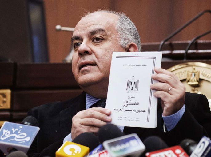 Egyptian Constitutional Assembly secretary general Amr Darrag holds a copy of the new Egyptian constitution draft on December 4, 2012 during a apress conference at the Shura Council in Cairo, Egypt. Egypt's top judges said they would ensure judicial oversight of a referendum on a draft constitution