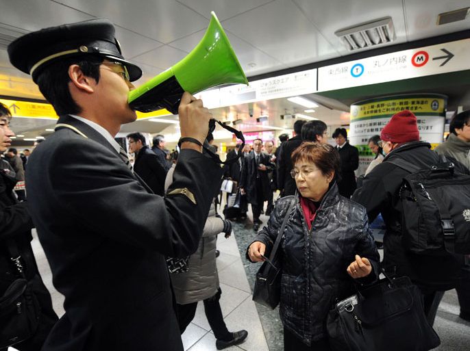 JAPAN : A station attendant (L) uses a loudspeaker to explain the train service situations for the Tohoku Shinkansen (bullet train) which connects Tokyo and northern Japan at Tokyo Station on December 7, 2012 following a 7.3 earthquake and tsunami alert. A one metre-high tsunami hit northeast Japan after a powerful undersea quake struck off the coast which was devastated in last year's quake-tsunami disaster. AFP PHOTO/Toru YAMANAKA