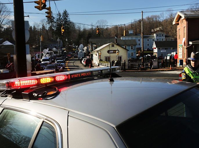 : Police officers keep guard at the entrance to the street leading to the Sandy Hook School on December 15, 2012 in Newtown, Connecticut. Twenty six people were shot dead, including twenty children, after a gunman identified as Adam Lanza opened fire in the school. Lanza also reportedly had committed suicide at the scene. A 28th person, believed to be Nancy Lanza was found dead in a house in town, was also believed to have been shot by Adam Lanza.