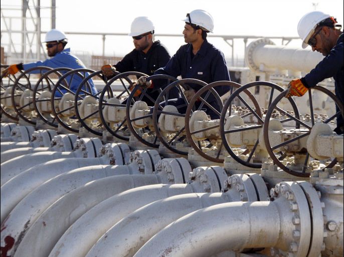 Workers adjust the valves of oil pipes at West Qurna oilfield in Iraq's southern province of Basra in this November 28, 2010 file photo.China National Petroleum Corp (CNPC) has emerged as the frontrunner to take over Iraq's West Qurna-1 oilfield from Exxon Mobil, a move that would diminish Western oil influence in Iraq a decade after the U.S.-led invasion. REUTERS/Atef Hassan/Files (IRAQ - Tags: ENERGY BUSINESS)