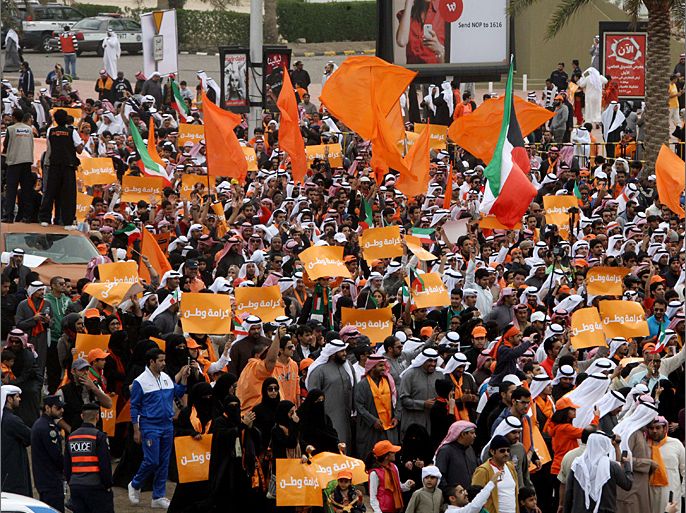Kuwaiti opposition supporters waving Kuwaiti and orange flags march on a major road in Kuwait City on December 8, 2012, during a demonstration to demand dissolving the new parliament elected last week amid a massive boycott as the oil-rich Gulf state plunged into political stalemate. The opposition supporters