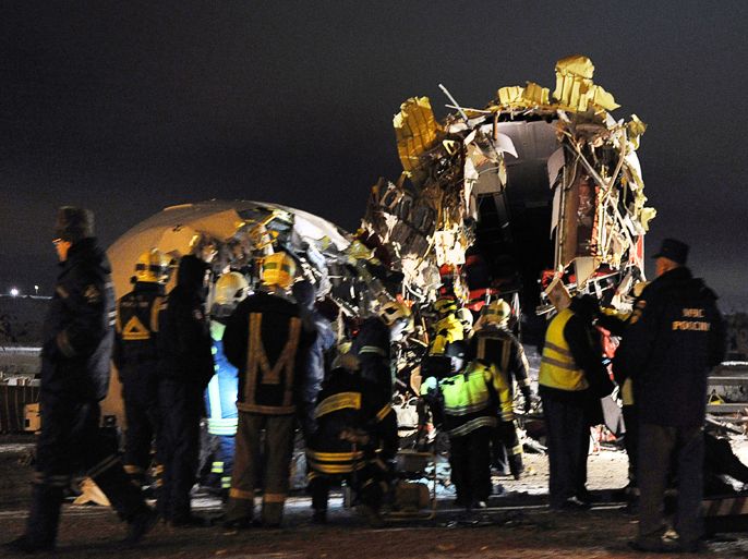 Moscow, -, RUSSIAN FEDERATION : Russian police investigators and emergency services teams work at the Tu-204 jet crash site near the Vnukovo airport outside Moscow on December 29, 2012. Four people were killed and four were injured when a Russian-made airliner overshot a runway on landing at a Moscow airport and crashed onto a nearby highway, officials said. AFP PHOTO