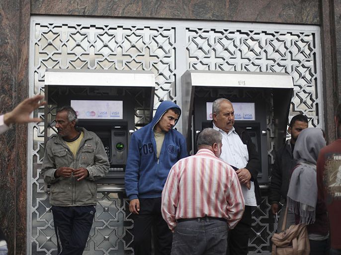 epa03481794 Palestinians queue to get money from ATMs at a Palestine Bank branch in Gaza City, on 22 November 2012. The Bank was the first one to reopen since the Israeli military operation against the Hamas-controlled Gaza strip. EPA/ALI ALI