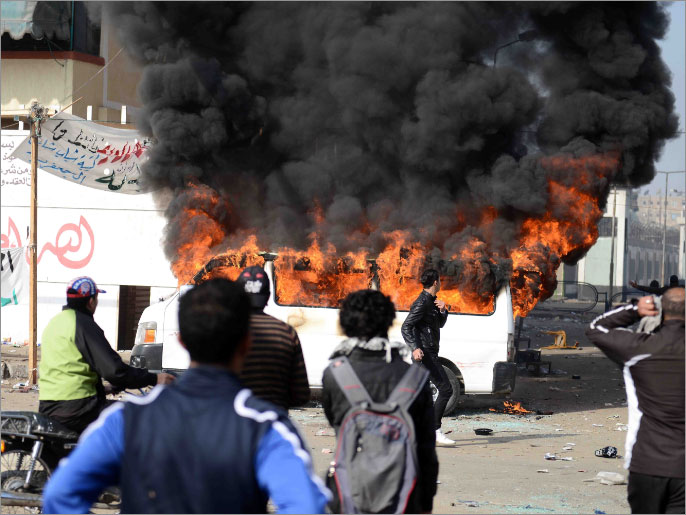 ‪محتجون يضرمون النار في إحدى السيارات بالقرب من سجن بورسعيد‬ (الفرنسية)