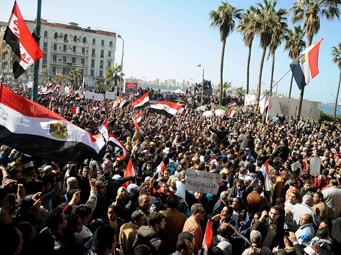 Egyptian demonstrator wave the national flag and shout slogans during a protest in Alexandria on January 25, 2013. Huge crowds are expected to demonstrate in Egypt on the second anniversary of the revolution that ousted Hosni Mubarak and brought in an Islamist government, as political tensions simmer and economic woes bite. AFP PHOTO/STR