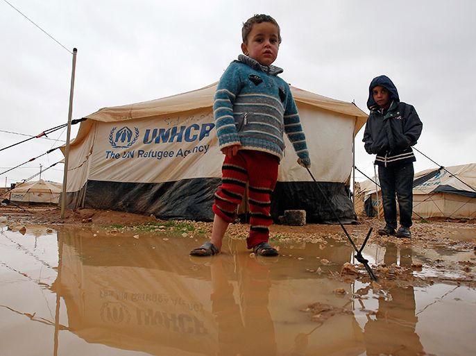 A Syrian refugee boy stands outside his parents' tent after heavy rain at the Al-Zaatari refugee camp in the Jordanian city of Mafraq, near the border with Syria, January 8, 2013. REUTERS/Ali Jarekji (JORDAN - Tags: POLITICS CIVIL UNREST TPX IMAGES OF THE DAY)