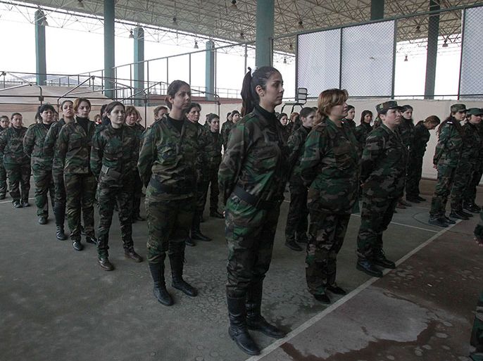 Syrian National Defense force women who just finished training, stand to attention at their training center in Wadi al-Dahab in the Syrian city of Homs, on January 21, 2013. Some 500 women are being trained and will help other National Defence force recruits at checkpoints and with other security tasks. AFP PHOTO/ANWAR AMRO