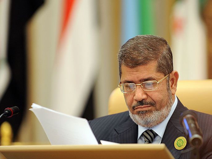 Egypt's President Mohamed Mursi looks at documents at the start of the third Arab Economic, Social and Development Summit, on January 21, 2013, in Riyadh. Saudi Arabia is hosting the two day summit aimed at relaunching regional cooperation in the face of economic challenges which were at the root of the Arab Spring uprisings. AFP PHOTO/FAYEZ NURELDINE