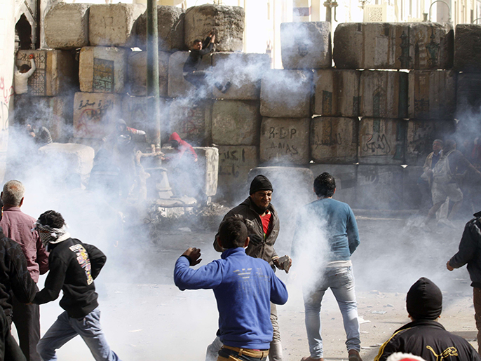 متظاهرون يحاولون هدم متاريس تمنعهم من مهاجمة وزارة الداخلية (الفرنسية)
