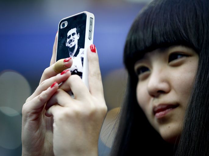 epa03418074 A spectator uses a mobile phone with the face of Serbia's Novak Djokovic on the back to take pictures of Djokovic before his first round match against opponent Michael Berrer of Germany at the China Open in Beijing, China, 02 October 2012. EPA/DIEGO AZUBEL