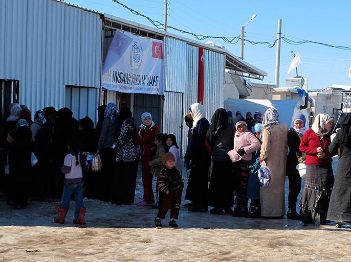 Syrian refugees queue to receive food and bread at Bab al-Salam refugee camp in Syria near the Turkish border January 10, 2013. Picture taken January 10, 2013. REUTERS/Abdalghne Karoof (SYRIA - Tags: CONFLICT SOCIETY)