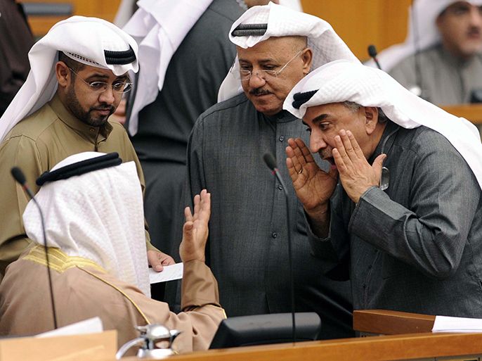 Kuwaiti MPs AbdulHameed Dashti (R), Nabeel al-Fadhel (C) and Hisham al-Baghli, talk to Kuwaiti Prime Minister Sheikh Jaber al-Mubarak al-Sabah (sitting) during a parliament session at Kuwait National Assembly in Kuwait City on January 8, 2013. Kuwait parliament overwhelmingly approved the controversial electoral decree that caused the opposition in the oil-rich Gulf state to boycott the December 1 general elections. AFP PHOTO/YASSER AL-ZAYYAT