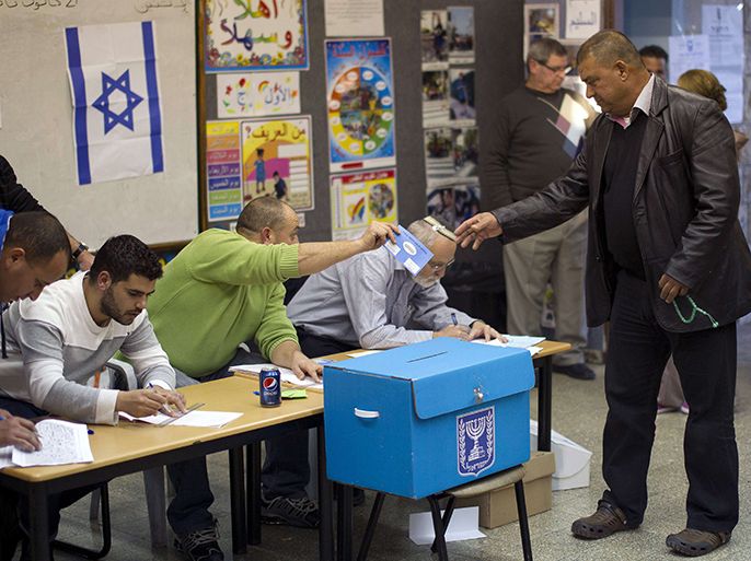 An Arab-Israeli man takes a ballot from a polling station official as he arrives to vote in the northern Arab-Israeli town of Sakhnin on January 22, 2013. Voters across Israel and in settlements peppering the occupied West Bank cast ballots for the Israeli general election at more than 10,000 polling stations, with turnout standing at 38.3 percent after seven hours of voting. AFP PHOTO/AHMAD GHARABLI