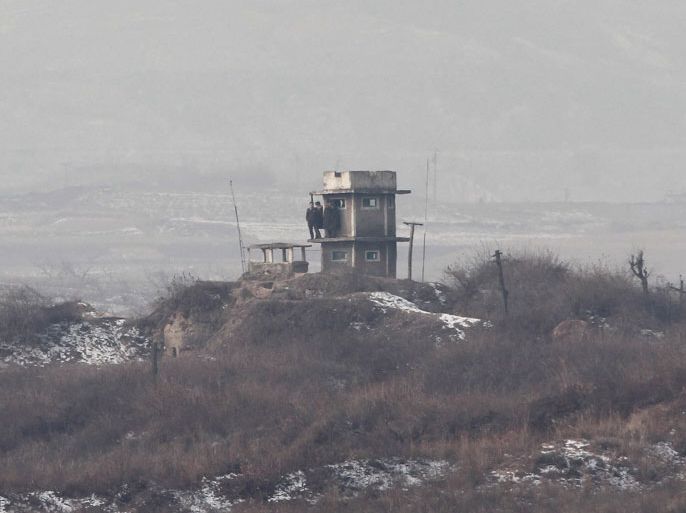 epa03044016 North Korean soldiers stand guard at sentry post near the Military Demarcation Line in the Demilitarized Zone (DMZ), that separates the two Koreas since the Korean War, in the border village Panmunjom in Gyeonggi-do, South Korea, 28 December 2011. North Korea was to hold a state funeral for its former leader Kim Jong-il on 28 December as the communist state's military and political elites reiterated their loyalty to new leader Kim Jong-un and millions of North Korean citizens were mobilized to pay their last respects to the deceased 'Dear Leader.' EPA/JEON HEON-KYUN/POOL