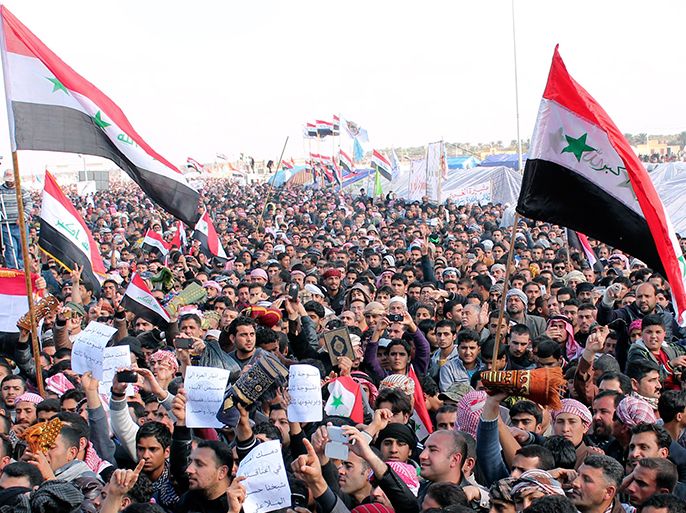 Sunni Muslims wave an old flag of Iraq (R) during an anti-government demonstration in Ramadi, 100 km (62 miles) west of Baghdad, February 1, 2013. REUTERS/Ali al-Mashhadani (IRAQ - Tags: POLITICS CIVIL UNREST)