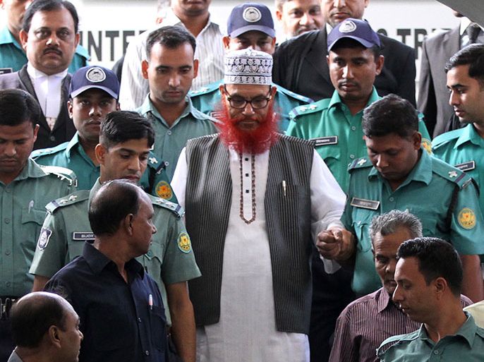 In this photograph taken on November 20, 2011, Jamaat-e-Islami leader Delwar Hossain Sayedee (C) is escorted by security personnel as he emerges from the Bangladesh International Crimes Tribunal in Dhaka. A special Bangladeshi court sentenced a senior Islamist opposition official to death on February 28, 2013, for crimes such as murder and religious persecution during the 1971