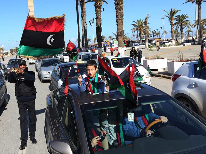 Libyan people wave flags near the Martyrs square as they celebrate, two days ahead of the second anniversary of the uprising that toppled the regime of strongman Moamer Kadhafi on February 15, 2013 in Tripoli. The government has already taken a series of measures to contain any attempt by supporters of the former regime to "sow chaos" amid anger from protesters who accuse the new rulers of failing to push for reform