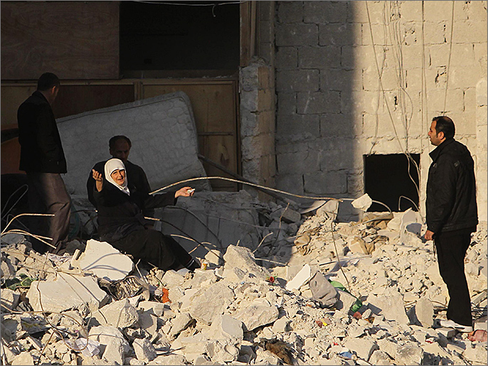 مواطنون يقفون على أنقاض منازلهم المدمرة في حلب (رويترز)