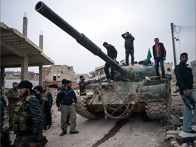 Syrian rebels gather around a T-72 tank, captured from government forces two months ago, in the village of Kfarruma in the flashpoint Syrian province of Idlib near the border with Turkey, on February 10, 2013. The rebels control large swathes of territory in northern and eastern Syria but have made little headway in major Syrian cities, where military stalemates have persisted for months. AFP PHOTO/DANIEL LEAL-OLIVAS