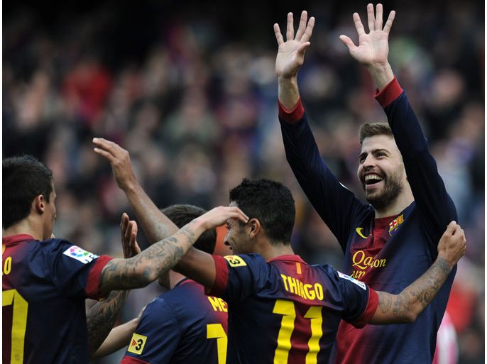 Barcelona's defender Gerard Pique (R) celebrates with teammates after scoring during the Spanish league football match FC Barcelona vs Getafe at the Camp Nou stadium in Barcelona on February 10, 2013. AFP PHOTO/ LLUIS GENE