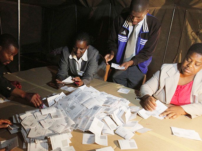 Zimbabwean election officials count ballot papers after the close of voting on a referendum in Harare, March 16, 2013. Zimbabweans voted on Saturday in the referendum expected to endorse a new constitution that would trim presidential powers and pave the way for an election to decide whether Robert Mugabe extends his three-decade rule. Picture taken March 16, 2013. REUTERS/Philimon Bulawayo (ZIMBABWE - Tags: POLITICS ELECTIONS)
