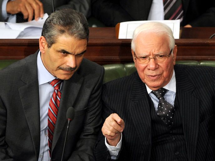 Tunisian defence minister candidate Rachid Sabbagh (R) chats with justice minister candidate Nadhir Ben Ammou (L) during a parliament session held to vote on a new government in Tunis on March 12, 2013. A street vendor in Tunis suffered severe burns when he set himself alight in an act of desperation hours before a vote on a new government to pull Tunisia out of a long-running political crisis. AFP PHOTO / FETHI BELAID