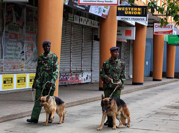 Kenyan policemen with dogs patrol the street near the Supreme Court in capital Nairobi March 30, 2013. Kenya's Supreme Court said on Saturday it would issue its ruling no later than 1400 GMT on legal challenges to Uhuru Kenyatta's win in a presidential election seen as a test of democracy, five years after vote disputes triggered widespread bloodshed. REUTERS/Noor Khamis (KENYA - Tags: ELECTIONS POLITICS)