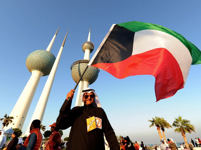 A Kuwaiti protester waves the national flag during a protest asking voters to boycot Parliamentary elections, in Kuwait City, Kuwait, 30 November 2012. Tens of thousands marched in Kuwait on 30 November 2012, at the Gulf Roud in front the Kuwaiti tewers. The demonstrators chanted slogans calling to overturn the decree which changed the voting rules thereunder. Kuwaitis are to elect a new parliament on 01 December for the second time in 2012, amid opposition calls for a boycott and warnings by the emir of an Arab Spring-style instability in the Gulf state