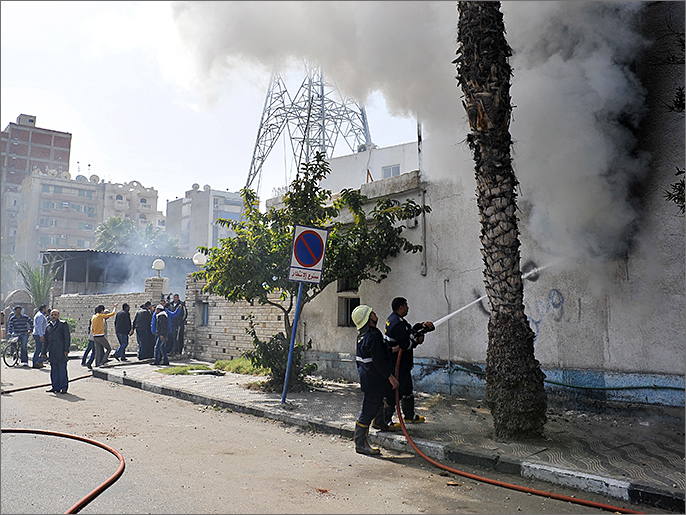 ‪رجال أطفاء يحاولون السيطرة على الحريق الذي أشعله محتجون بقسم للشرطة في بورسعيد‬  رجال أطفاء يحاولون السيطرة على الحريق الذي أشعله محتجون بقسم للشرطة في بورسعيد (الفرنسية)