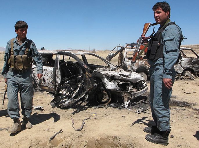 epa03645026 Afghan police inspect wreckages of vehicles which were destroyed in an alleged NATO airstrike in Esfandeh village in Ghazni province, Afghanistan, 30 March 2013. According to reports, at least two Afghan boys and seven Taliban were killed while 12 civilians including women were injured in NATO airstrikes in Ghazni. EPA/NAWEED HAQJOO
