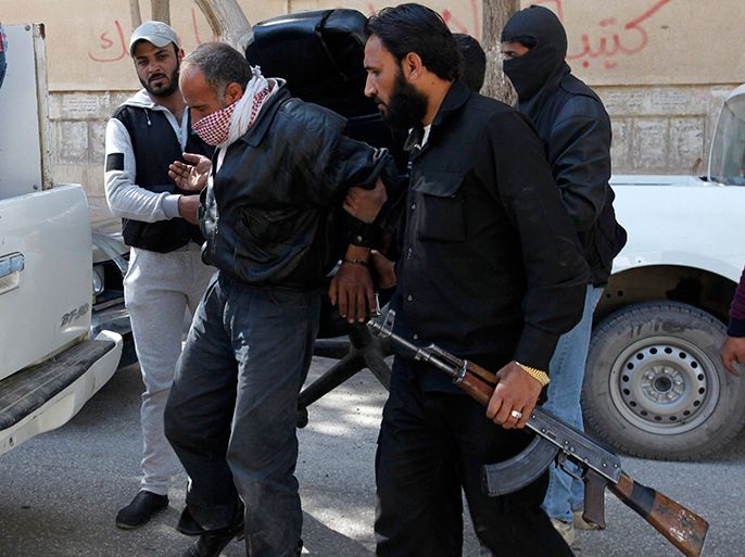 Members of Islamist Syrian rebel group Jabhat al-Nusrain hold a detainee as they transport him in Raqqa province, eastern Syria, March 14, 2013. REUTERS/Hamid Khatib (SYRIA - Tags: CONFLICT POLITICS)
