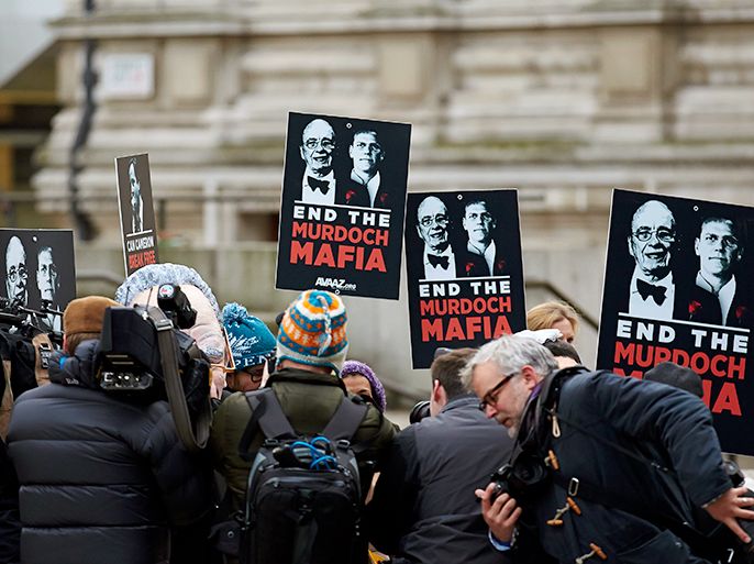 epa03490450 Media surrounded protestors holding banners reads on 'End The Murdoch Mafia' outside of Queen Elizabeth II conference center, in central London, England on 29 November 2012 where Lord Justice Leveson will publish his report finalizing Leveson inquiry about practices and ethics of the press. The alleged phone-hacking took place between 2000 and 2006, and affected hundreds of people ignited the phone-hacking scandal and led to the establishment of the Leveson inquiry, an investigation into press ethics, at which Rupert Murdoch, David Cameron and Rebekah Brooks appeared as witnesses. EPA/KERIM OKTEN