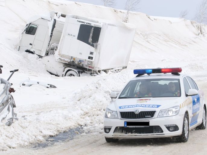 A police car arrives at the site of an accident involving a truck and cars at the E71 motorway, nearby the Croatian, Slovenian and Hungarian borders on March 15, 2013 a day after a heavy snow storm hit the area. A cold snap that caused havoc elsewhere in Europe sent temperatures plunging and blanketed large parts of Hungary in snow