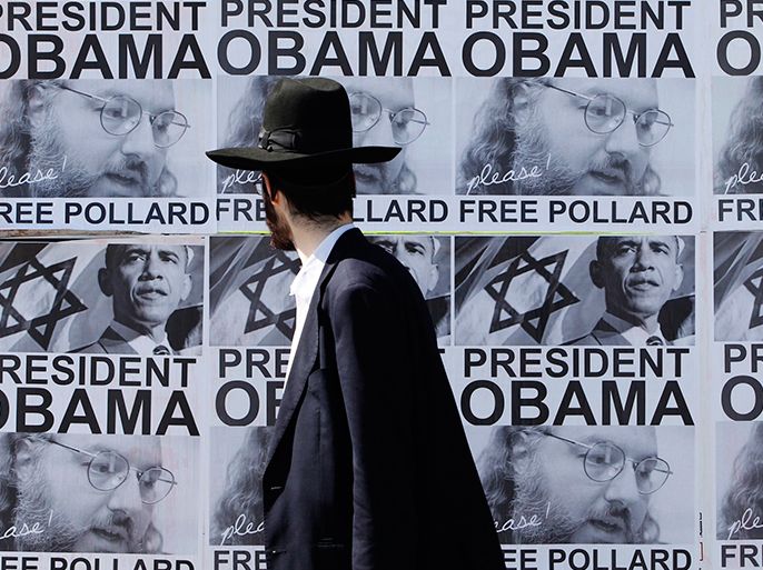 An ultra-Orthodox Jewish man walks past posters calling for U.S. President Barack Obama to free Jonathan Pollard from a U.S. prison, in Jerusalem March 20, 2013. Obama arrives in Israel on Wednesday without any new peace initiative to offer disillusioned Palestinians and facing deep Israeli doubts over his pledge to prevent a nuclear-armed Iran. Pollard, a former U.S. Navy intelligence analyst, has been serving a life sentence in the United States since he was caught spying for Israel in the 1980s. REUTERS/Baz Ratner (JERUSALEM - Tags: POLITICS)