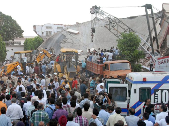 INDIA : Onlookers and rescue personnel are pictured at the scene of a hospital collapse in Bhopal on April 26, 2013. Up to 15 people, mostly patients, were feared trapped after part of a hospital roof caved in on Friday in the central Indian city of Bhopal, officials and eyewitnesses said. AFP PHOTO/STR
