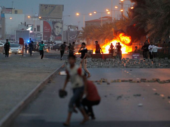 Protesters are seen on a street after setting fire to garbage containers during clashes with riot police in Budaiya, west of Manama April 19, 2013. REUTERS