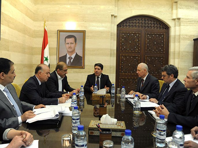 A handout picture released by the Syrian Arab News Agency (SANA) on April 29, 2013, shows Syrian Prime Minister Wael al-Halqi (C) chairing a cabinet meeting with the Economic Committee with a portrait of Syrian President Bashar al-Assad in the background. Halqi escaped an assassination bid, surviving a blast against his convoy in the Mazzeh district of Damascus, in the latest attack on top members of President Bashar al-Assad's regime. AFP PHOTO / SANA /HO == RESTRICTED TO EDITORIAL USE - MANDATORY CREDIT "AFP PHOTO / HO / SANA" - NO MARKETING NO ADVERTISING CAMPAIGNS - DISTRIBUTED AS A SERVICE TO CLIENTS ==