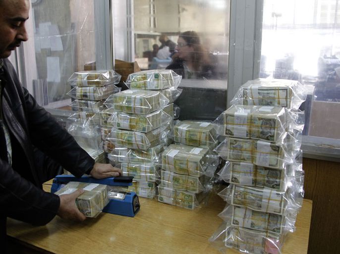An employee seals bags of Syrian pound notes at the Syrian central bank in Damascus April 23, 2013. Picture taken April 23, 2013. To match SYRIA-CURRENCY/ REUTERS/Khaled al-Hariri (SYRIA - Tags: POLITICS CONFLICT BUSINESS)
