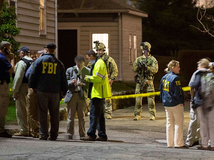 FBI and Boston Police officers stand in front of the house at 67 Franklin St. where Dzhokhar Tsarnaev, the surviving suspect in the Boston Marathon bombings, was hiding near in Watertown, Massachusetts, April 19, 2013. Boston Police said on Friday they have taken custody of the second suspect, Dzhokhar Tsarnaev, and are sweeping the suburban Boston neighborhood where he was captured after a massive manhunt. REUTERS/Lucas Jackson (UNITED STATES - Tags: CRIME LAW)