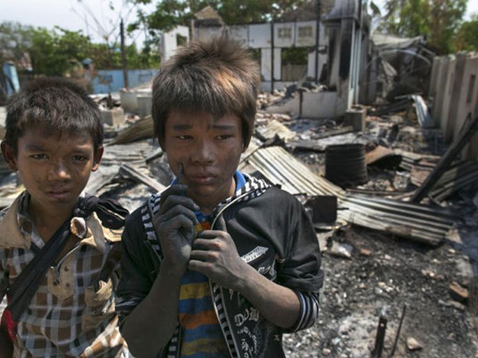 Two boys stand near their destroyed home April 5 in Meiktila, Myanmar. Recent sectarian violence between Buddhists and Muslims has left dozens dead, and Human Rights Watch said Monday that the attacks on Rohingya Muslims amount to crimes against humanity. (Paula Bronstein / Getty Images / April 22, 2013