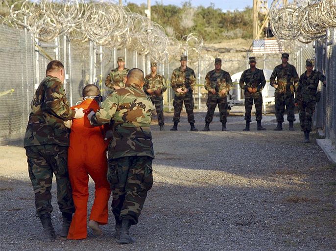 Caption:U.S. Army Military Police escort a detainee to his cell during in-processing to the temporary detention facility at Camp X-Ray in Naval Base Guantanamo Bay in this file photograph taken January 11, 2002 and released January 18, 2002. January 11, 2012 marks the 10th anniversary of the opening of the U.S. military detention camp at the Guantanamo Bay U.S. naval base in eastern Cuba.